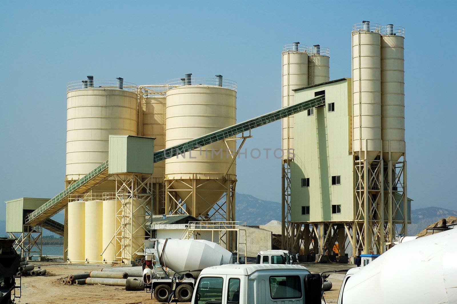 A shot of cememt factory with mixer trucks