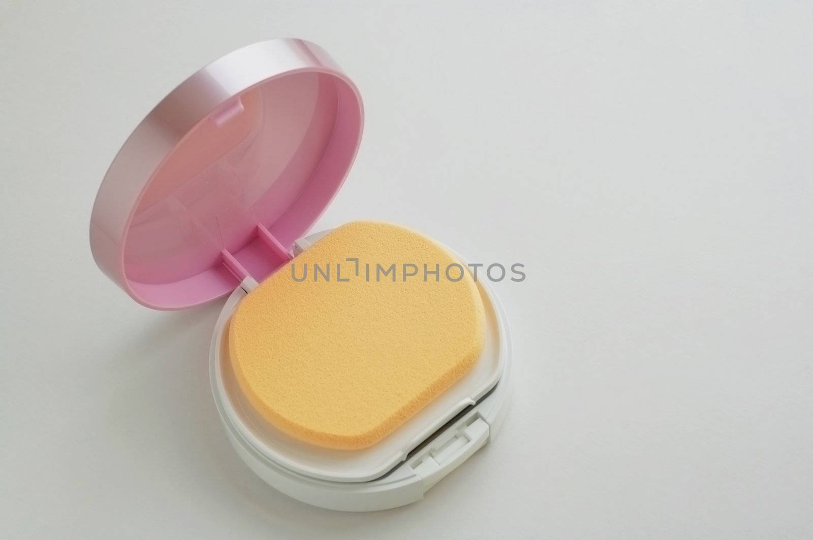 A vanity case of facepowder over white background