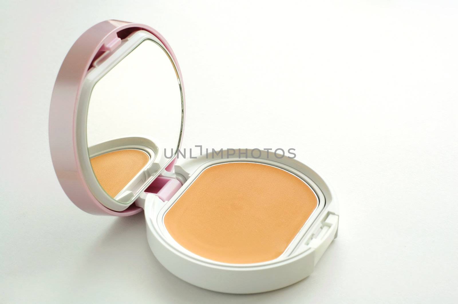 A vanity case of facepowder over white background