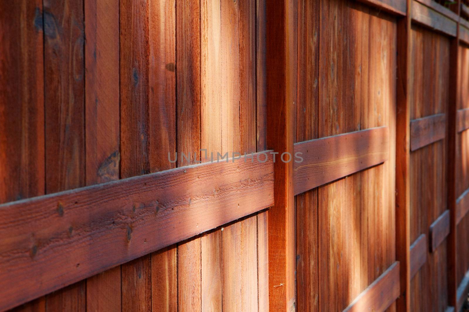 Red brown stained redwood fence in diminshing perspective