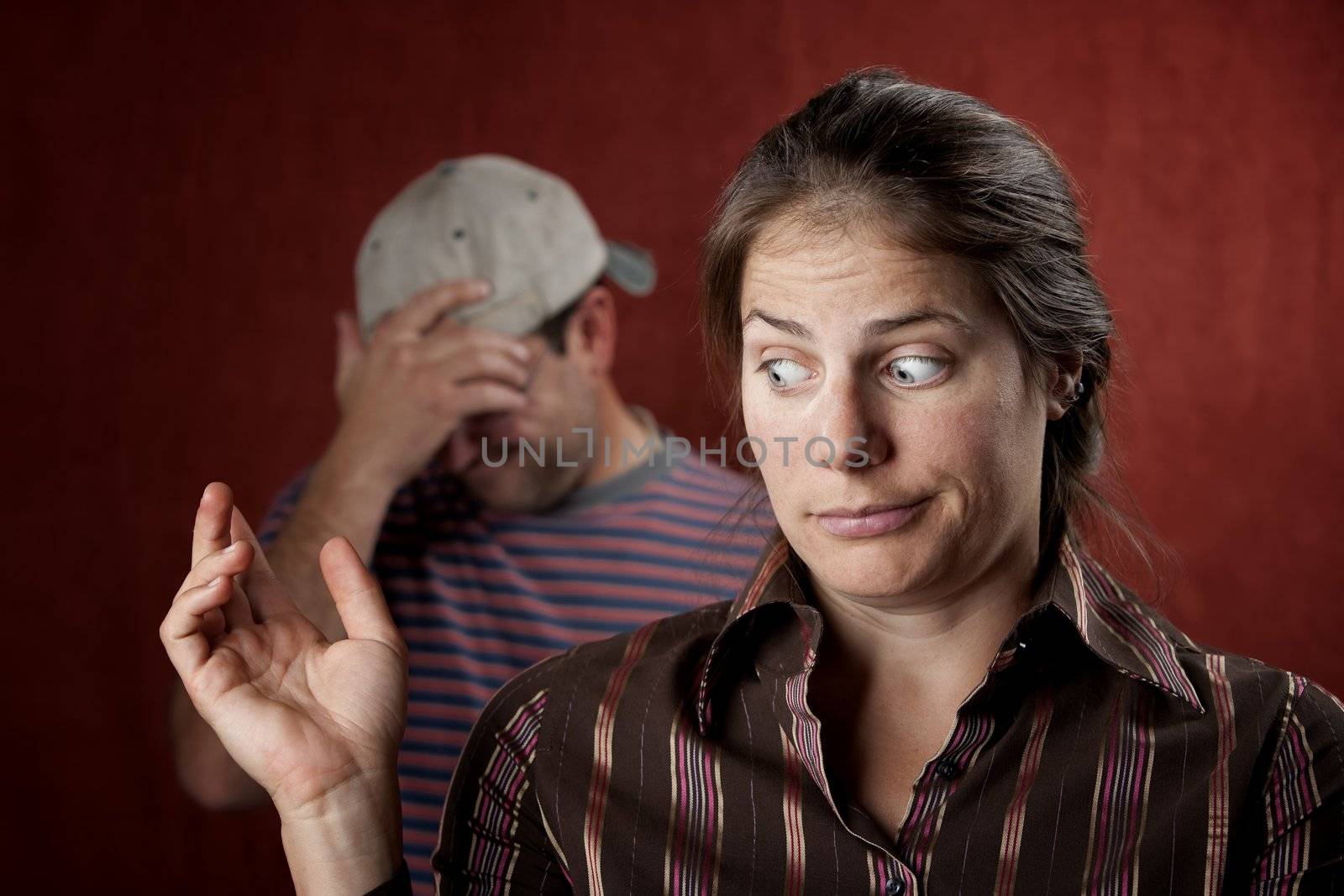 Guilty woman with upset man in the background