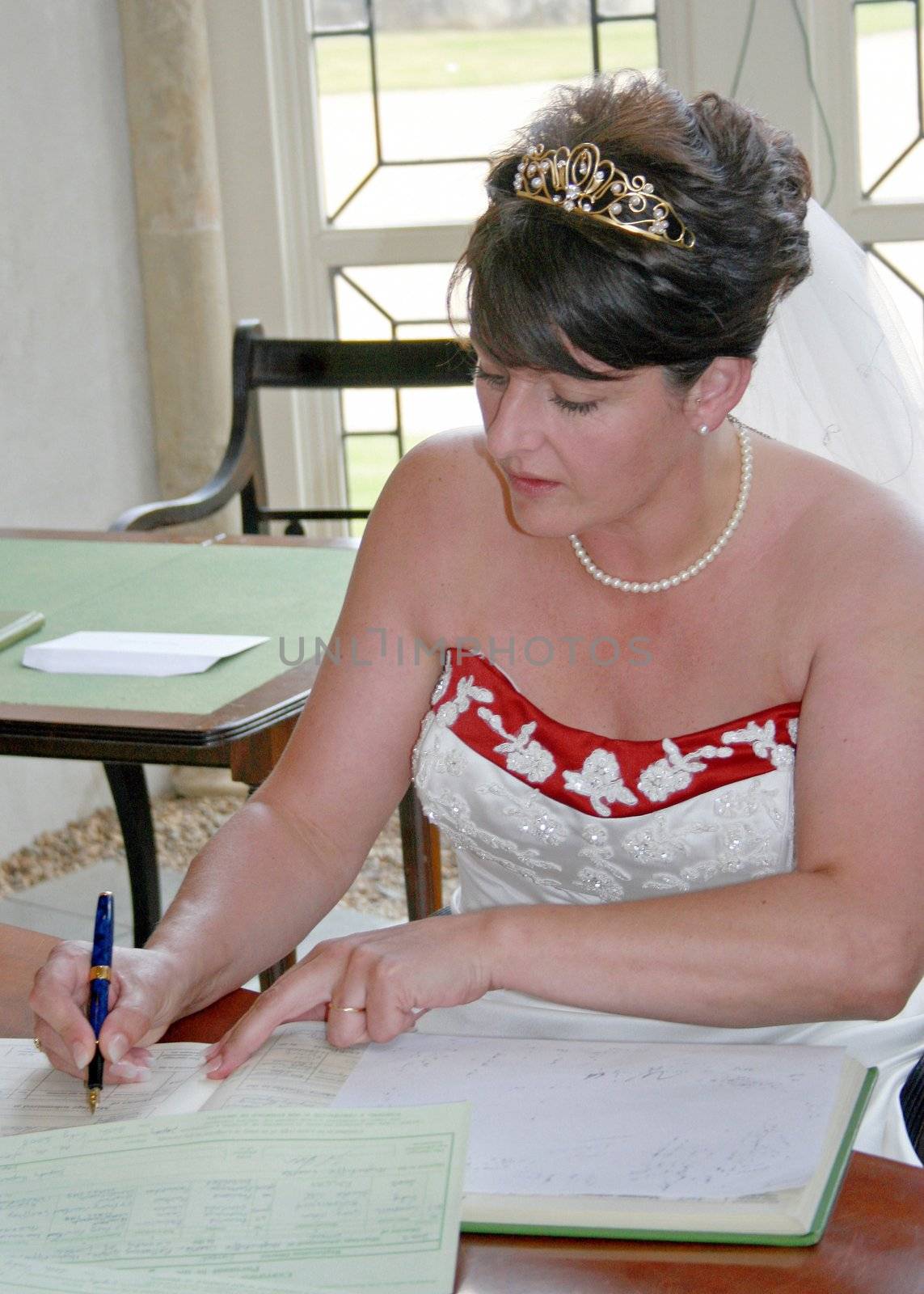 A Bride signing the register after her wedding.