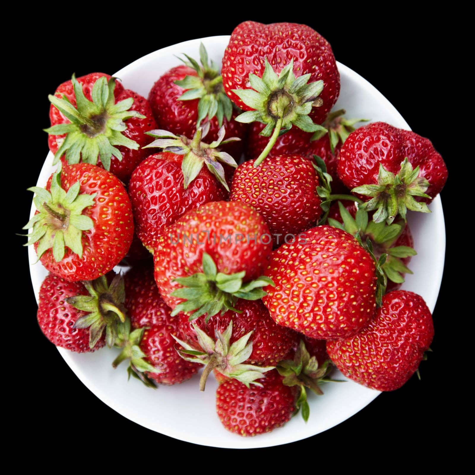 Strawberries on a plate isolated on a black background