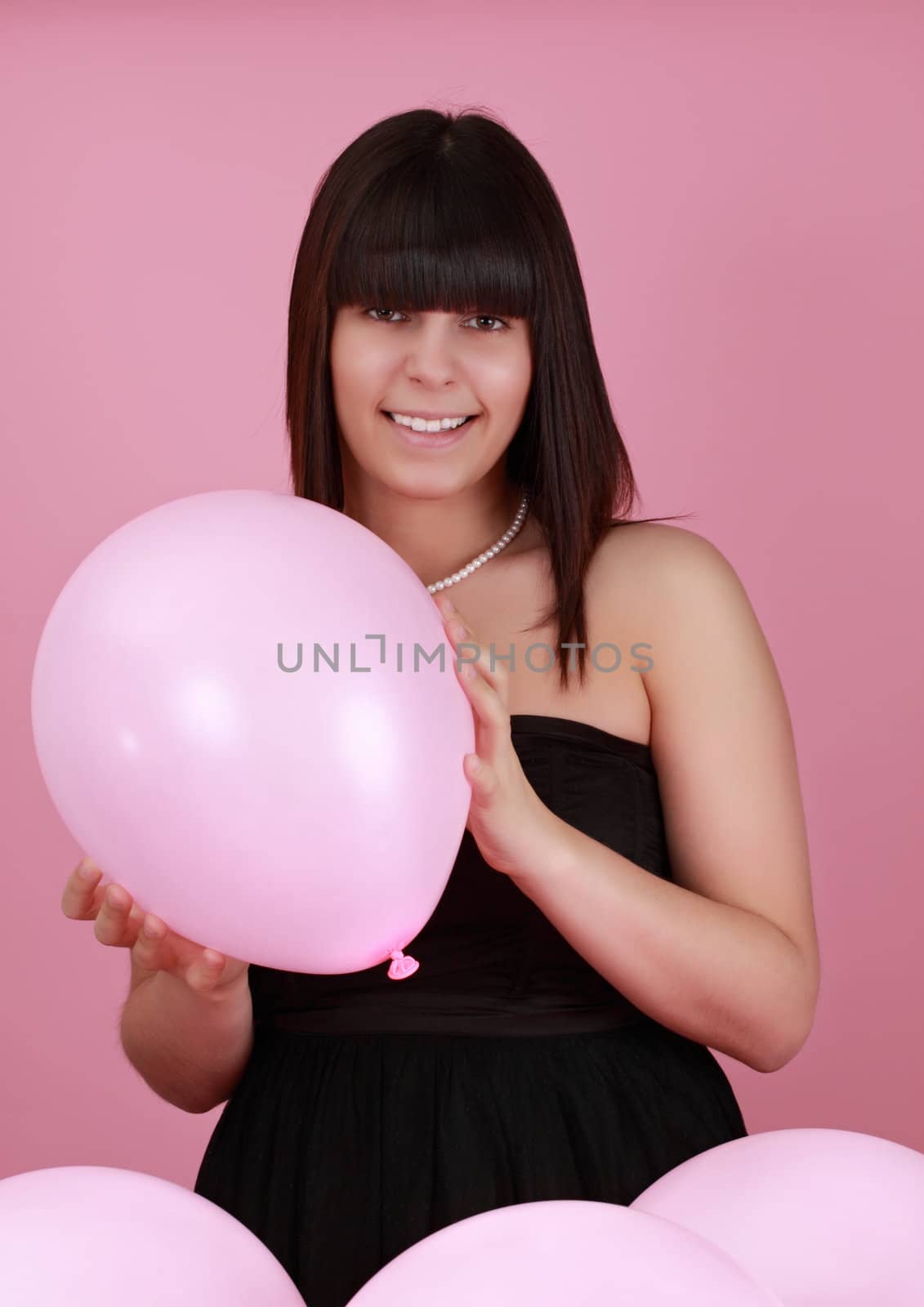 cute caucasian girl holding a pink balloon