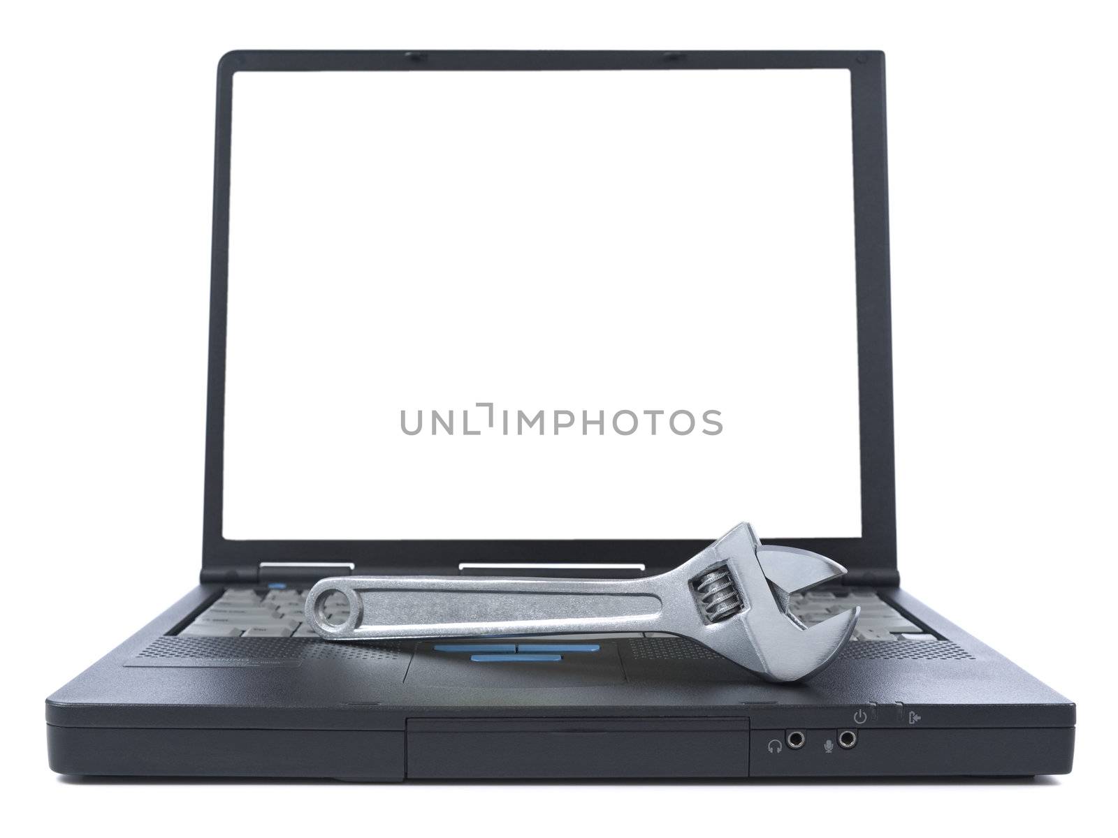 A spanner over a black laptop isolated over white background. White copy space on screen.