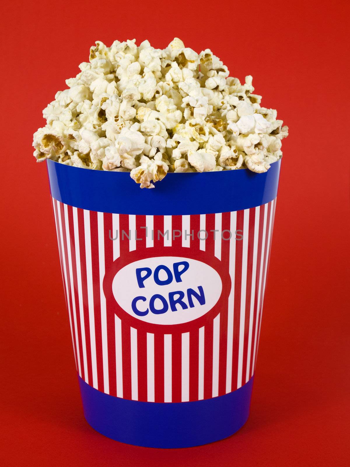 A popcorn bucket over a red background.