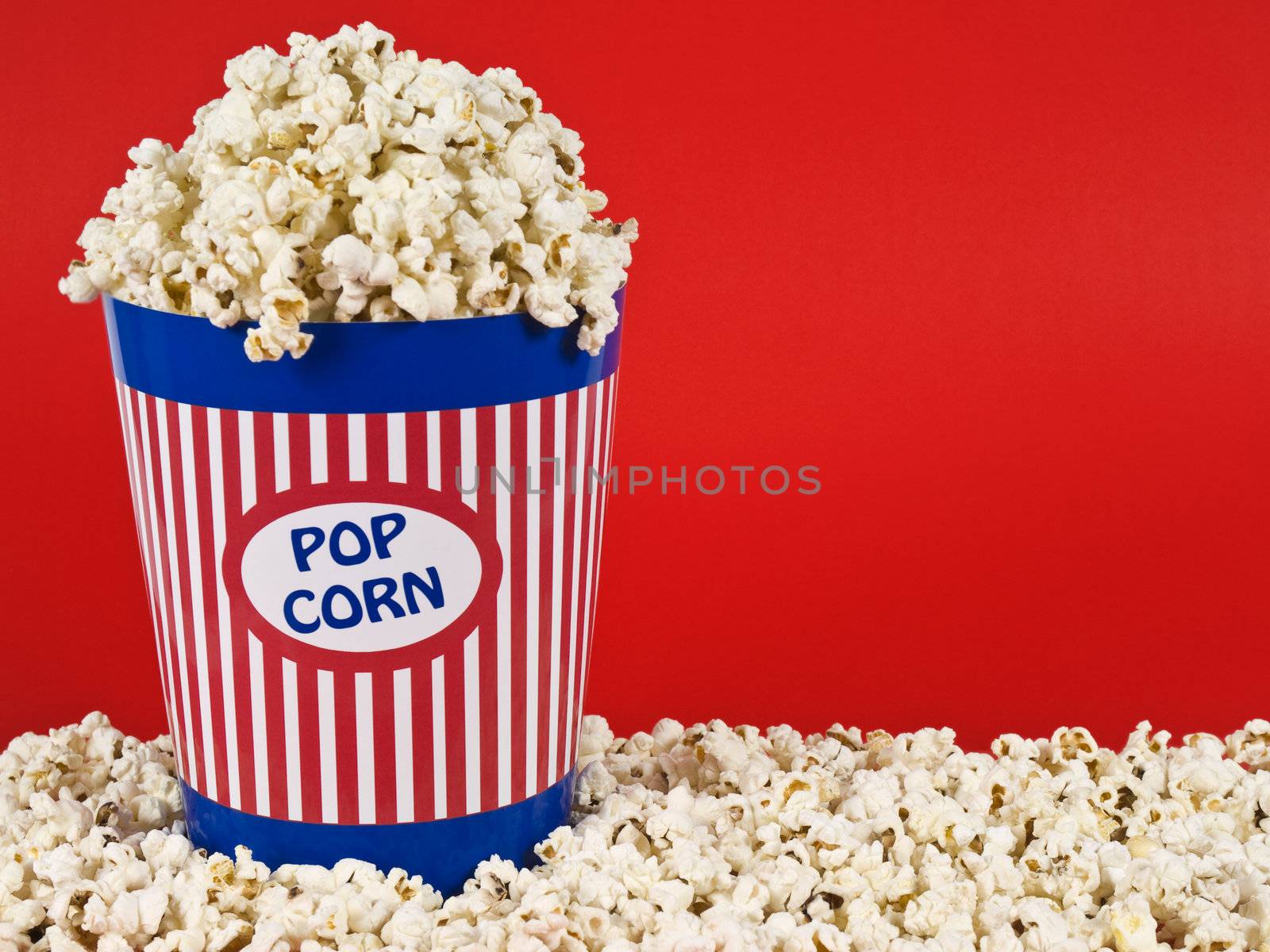 A popcorn bucket over a red background.