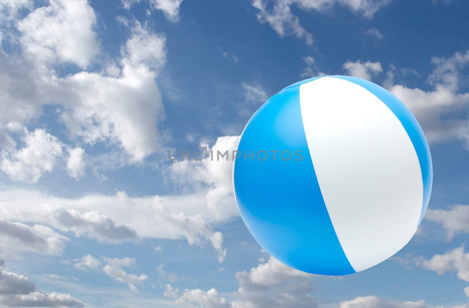 Striped beach ball against the sky