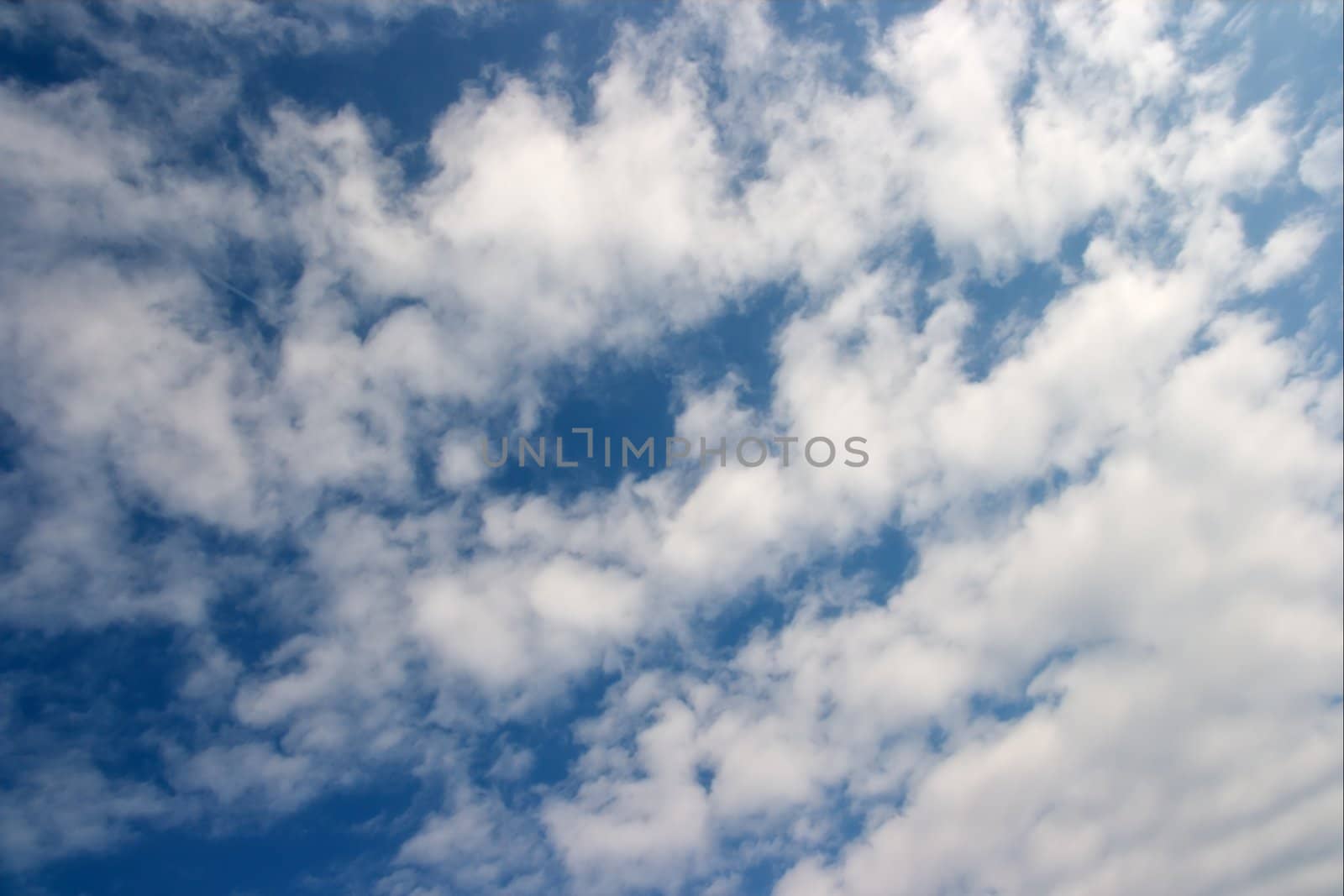 Small white clouds on clear blue sky