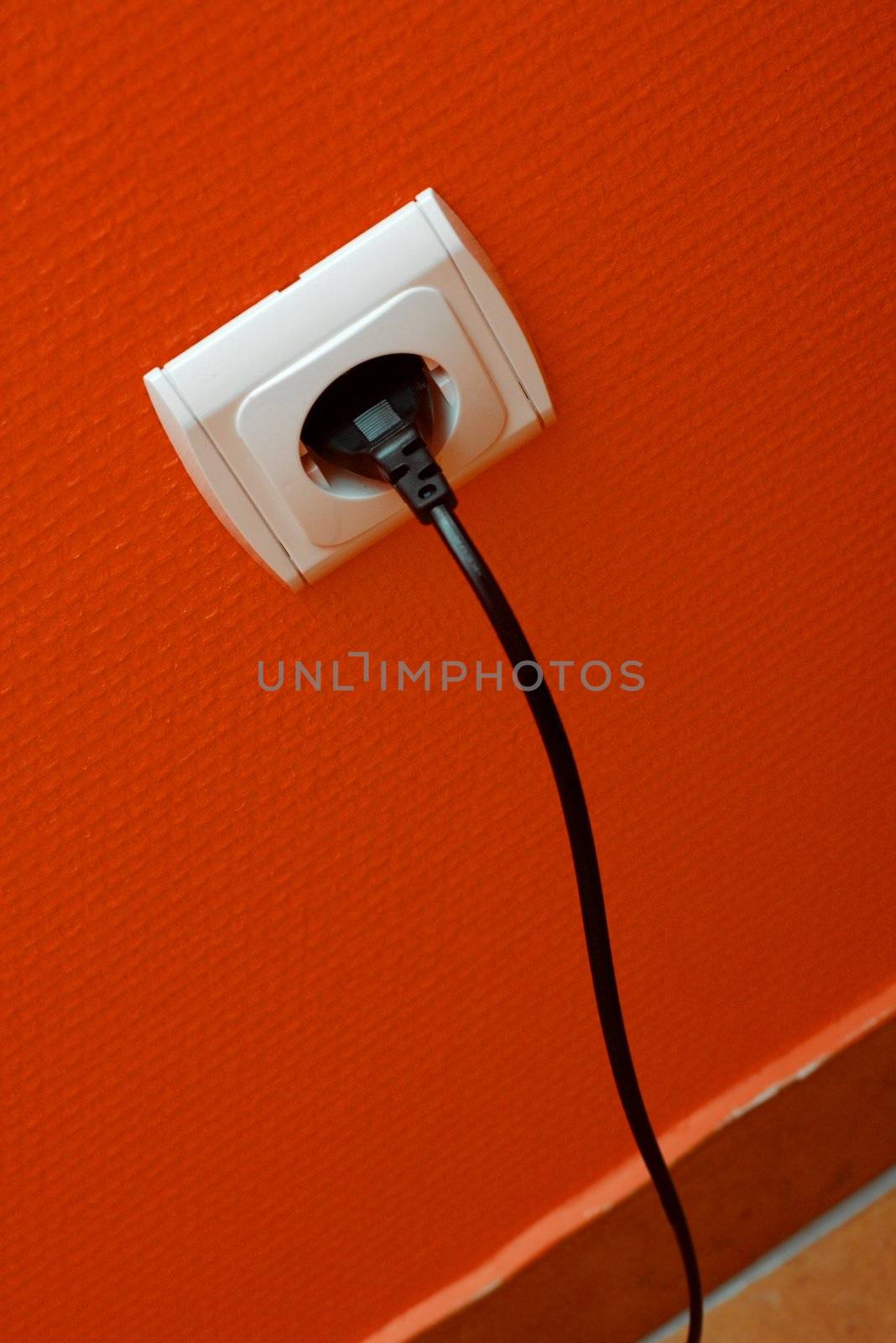 Electric cable plugged into the wall outlet