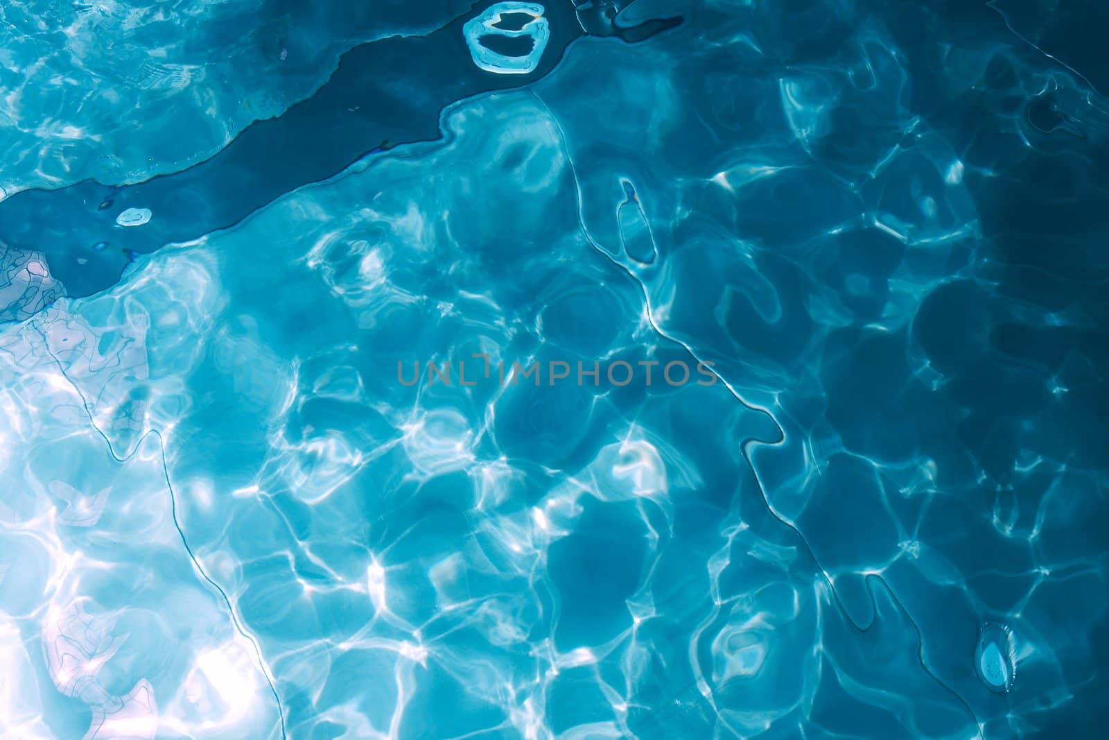 Rippling water of a pool with reflections in blue