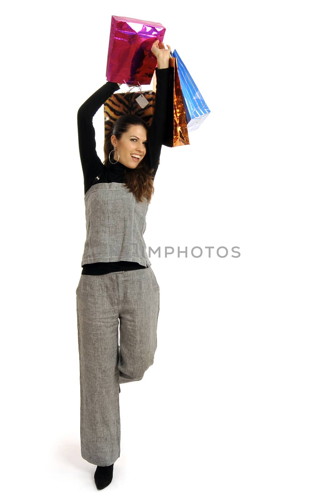 Full body view of young attractive woman in business wear,  going shopping with lots of colorful shopping bags. Isolated on white background.