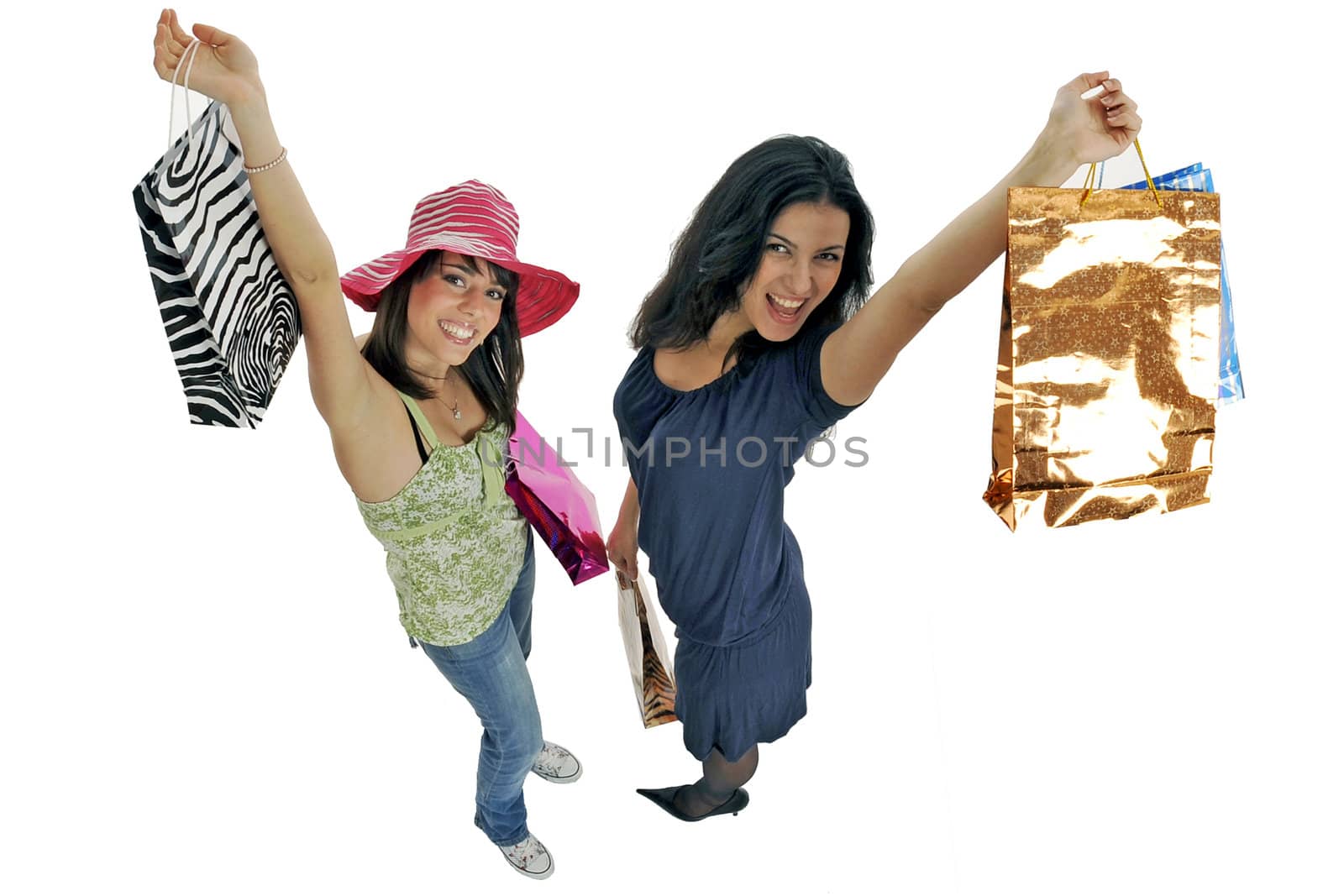 Full body view of two young attractive women going shopping with lots of colorful shopping bags. Isolated on white background.
