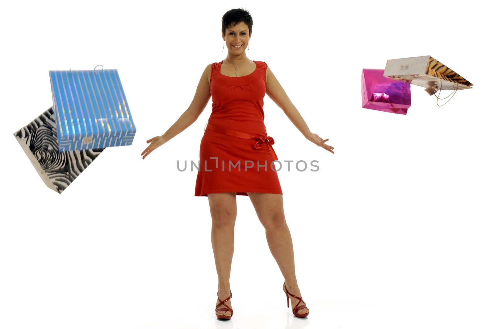 Full body view of young attractive woman throwing around lots of colorful shopping bags. Isolated on white background.