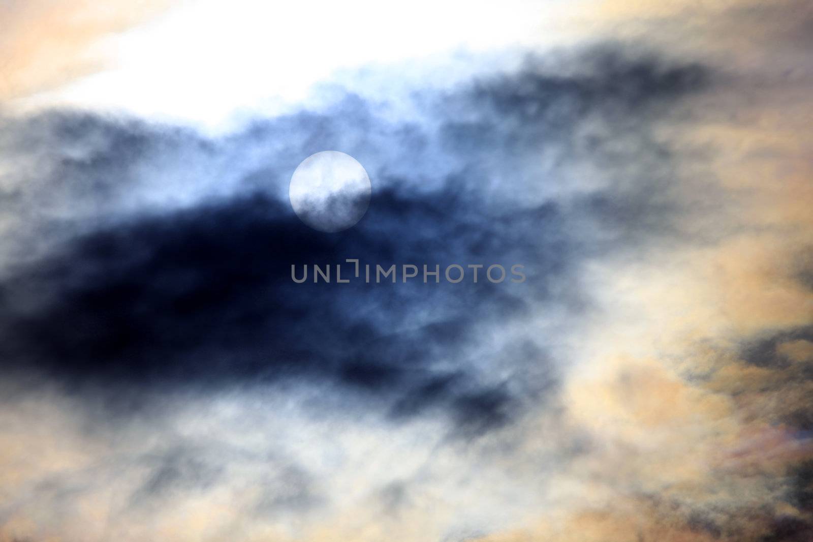The sun in clouds against light