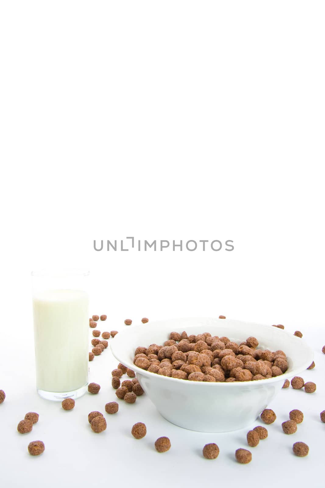 Chocolate balls with milk for breakfast in ceramic bowl. Isolated on white.