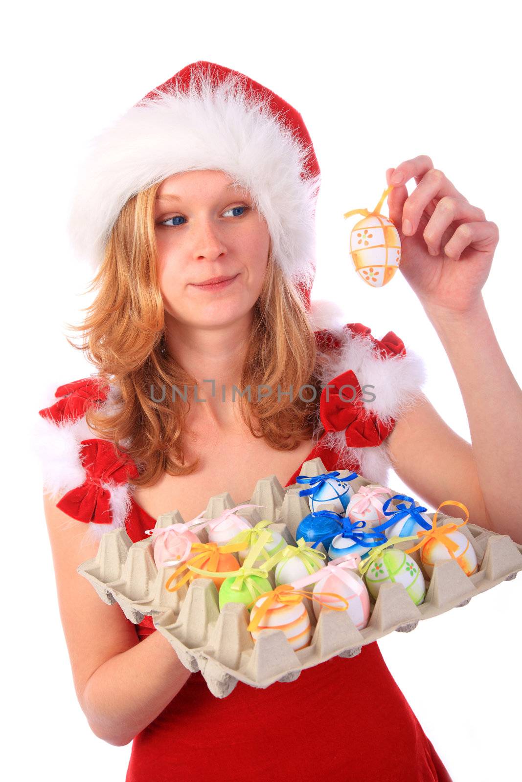 Miss Santa is holding a package of colourful easter eggs, one egg in her hand - sceptical surprised look