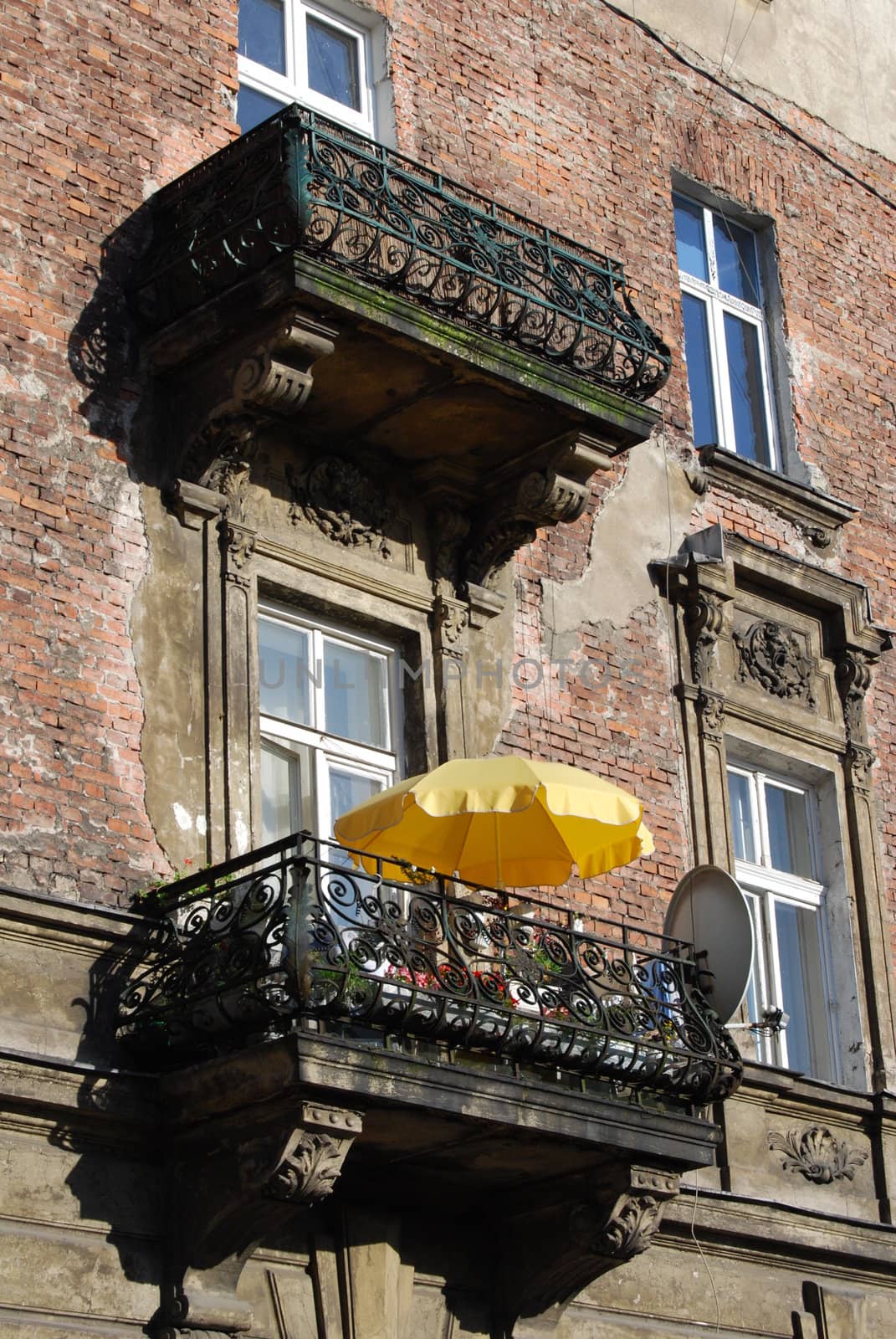 a window with yellow umbrella in krakow by neuartelena
