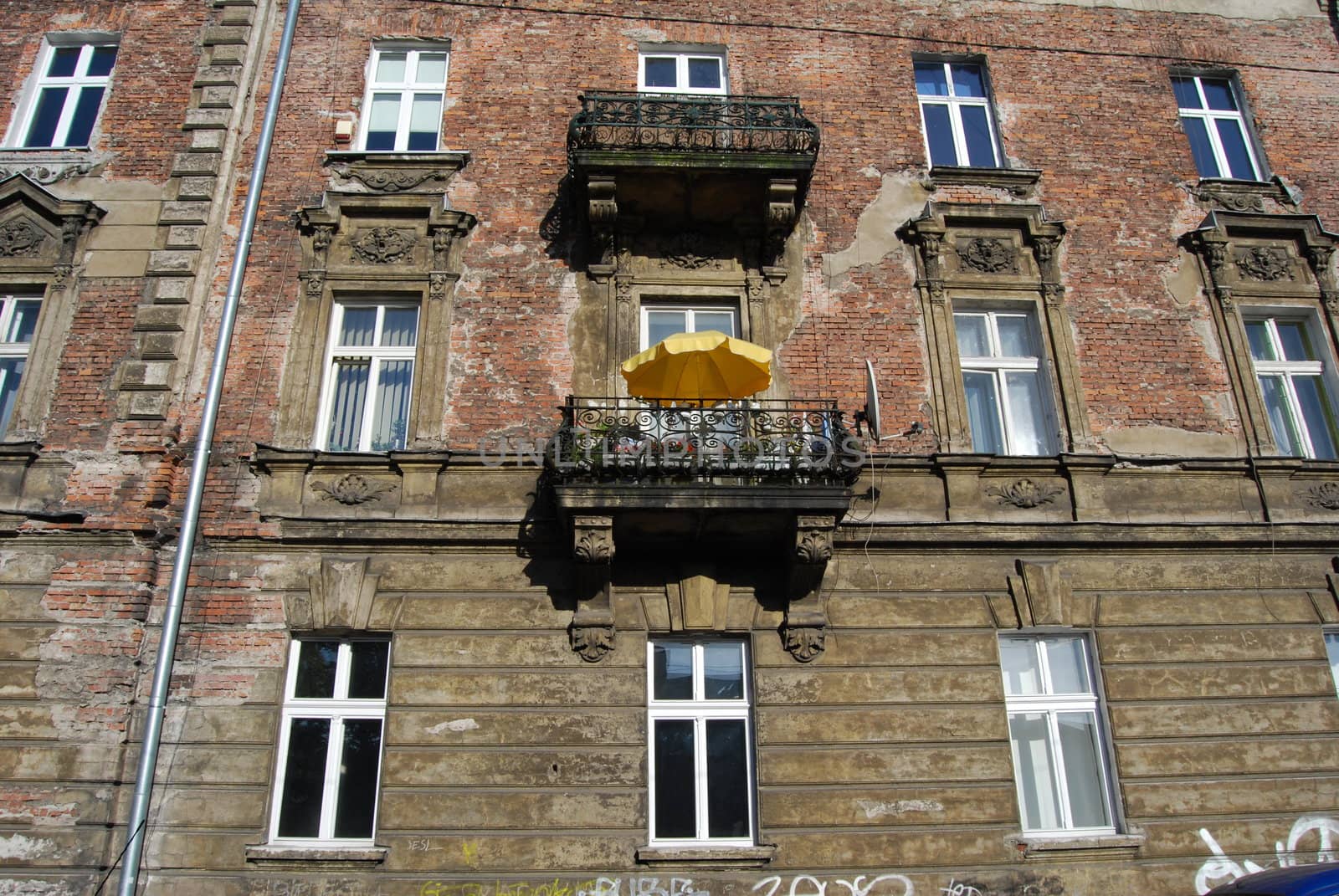 a window with yellow umbrella in krakow by neuartelena