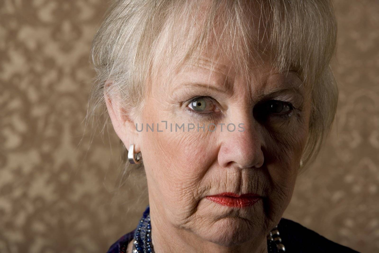 Closeup portrait of skeptical senior woman with bright lipstick