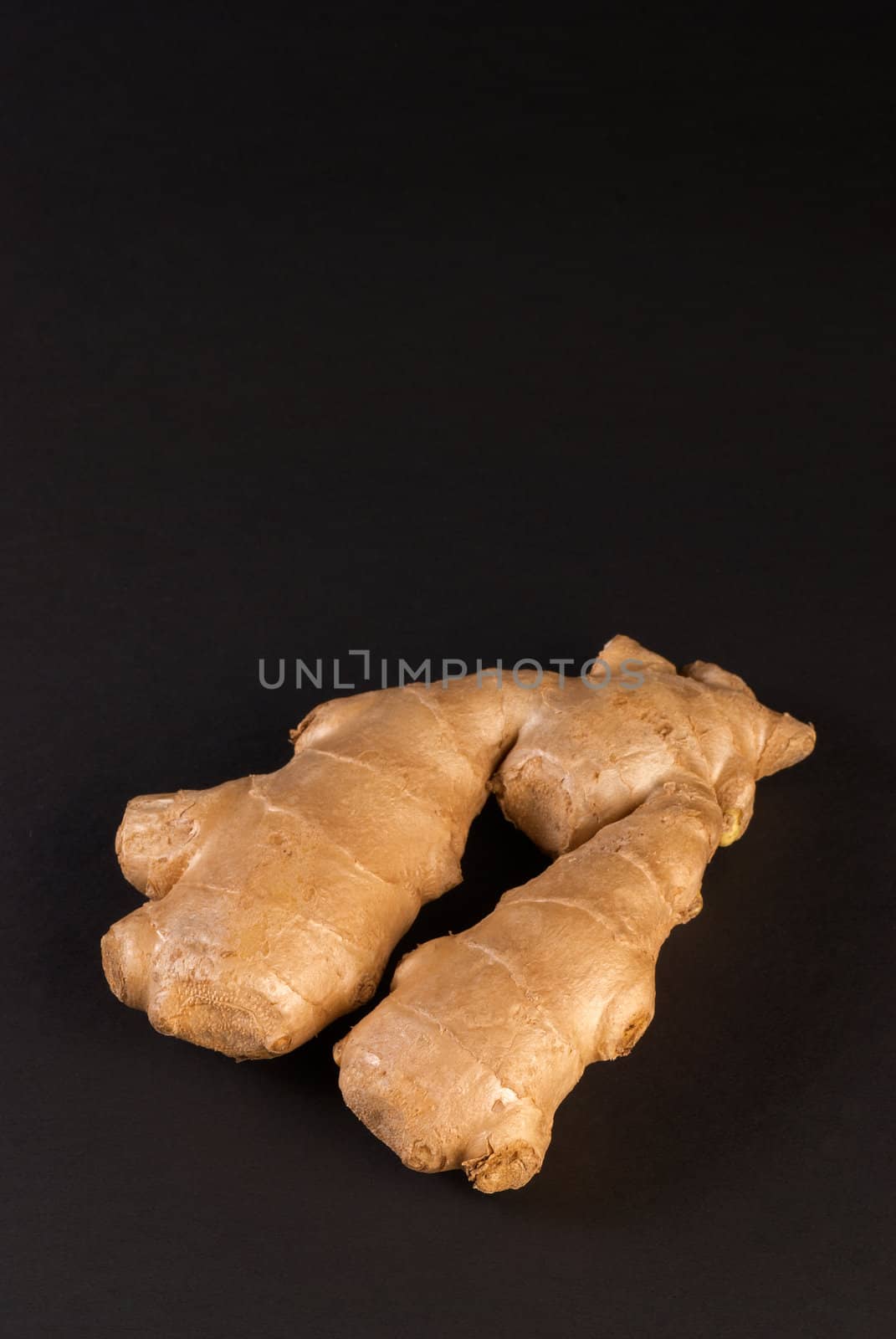 Raw ginger root taken on black background