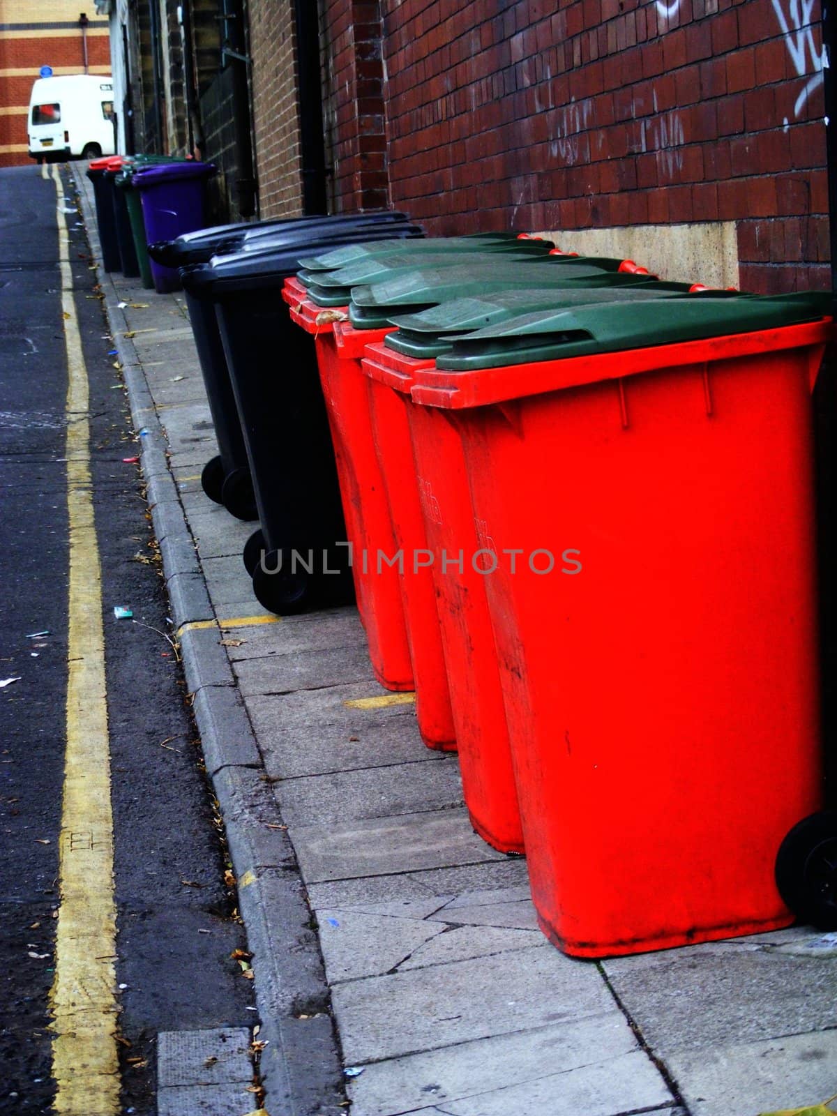 A photograph of street side red bins