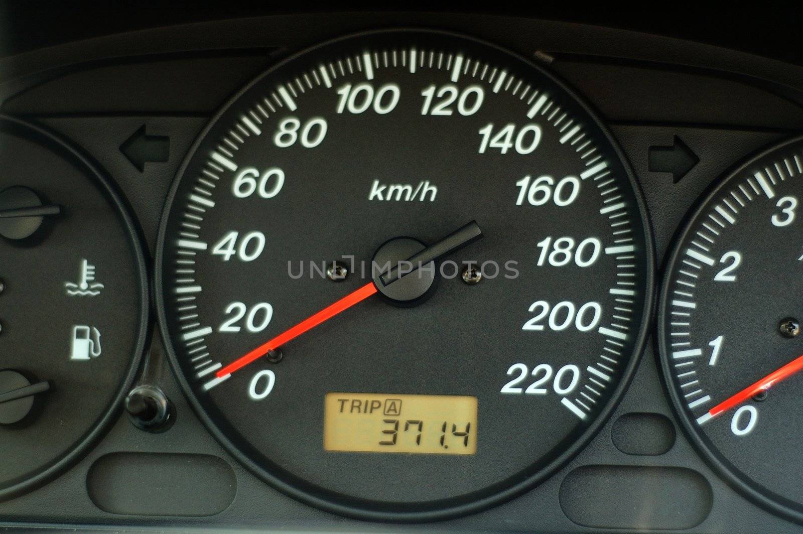A close up of car dashboard with speed over black background