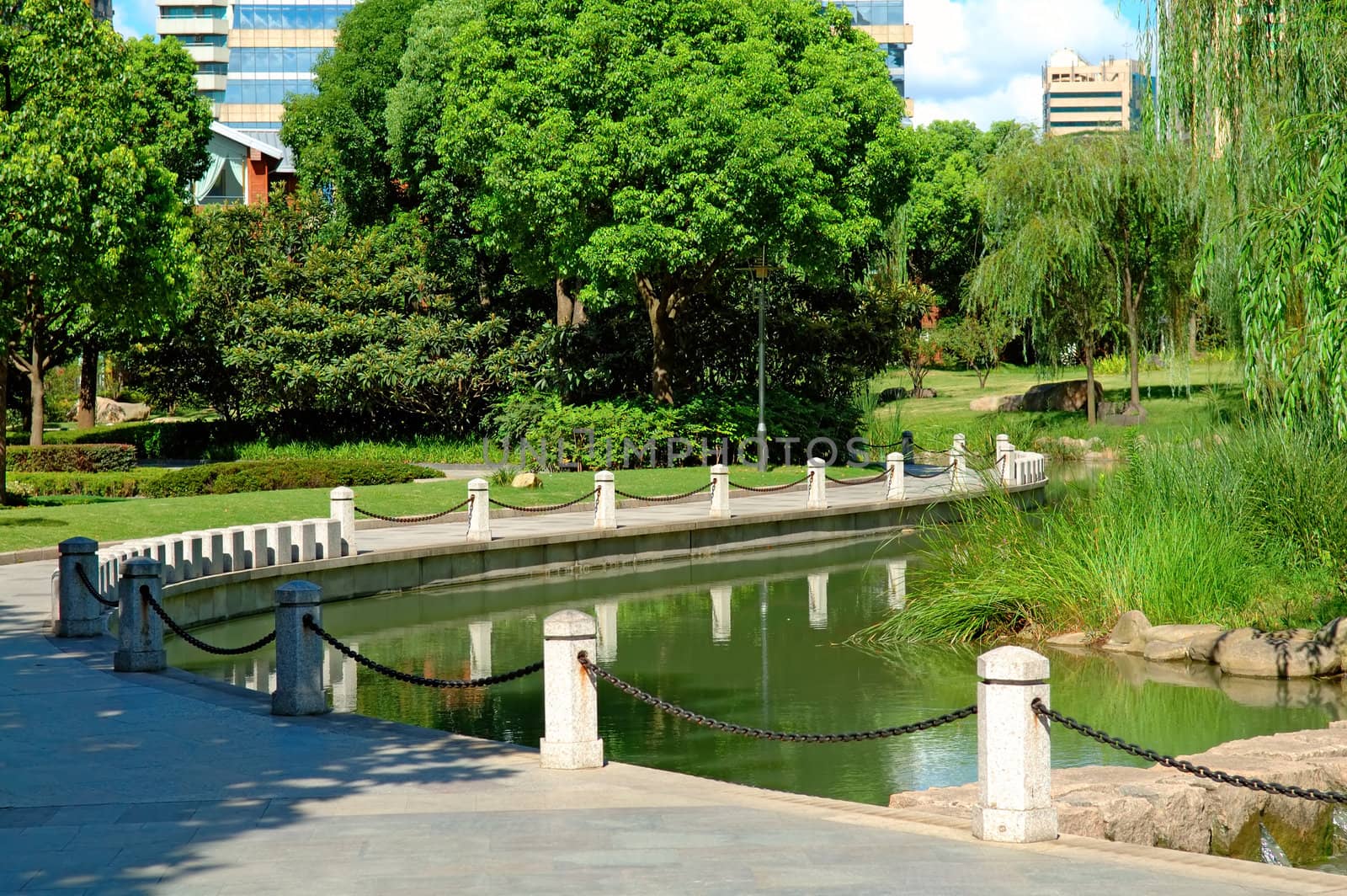 The view of walkway beside a pond in park