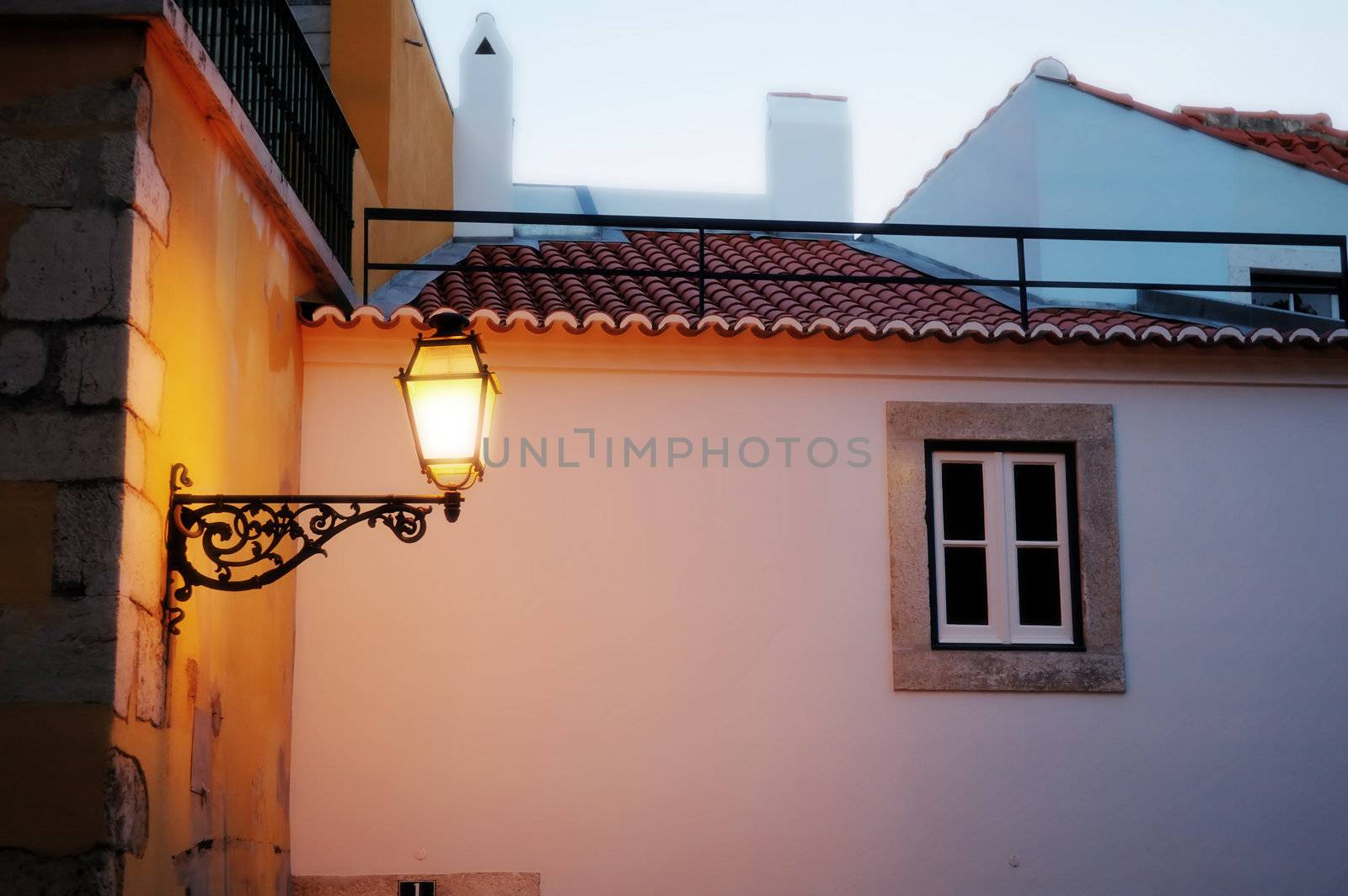The antique lantern (street lamp) hanging on the (exterior) wall of residential house