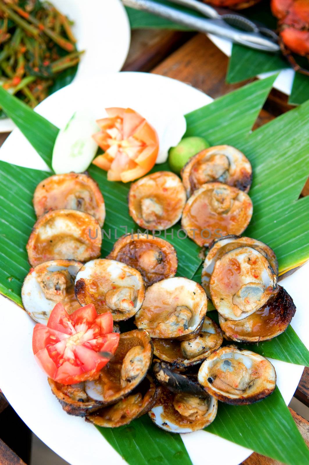 Grilled shell fish split in shell with garnish