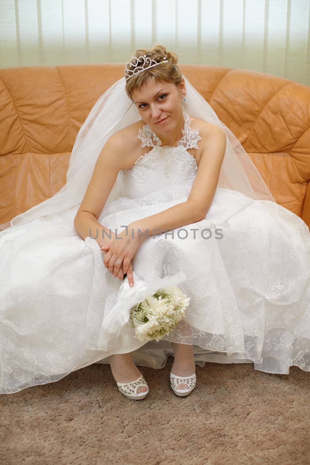 Bride sitting on the sofa waiting for the ceremony