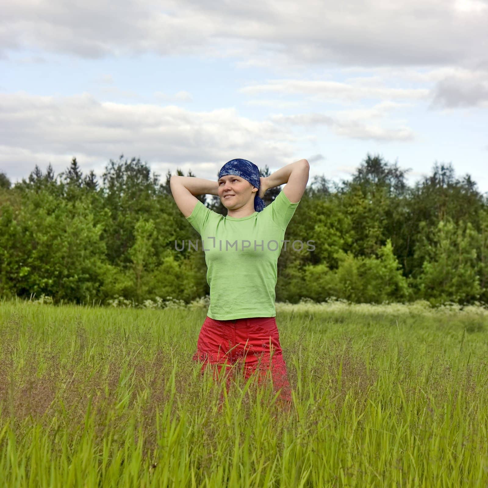 Photo of the smiling girl in the field against wood