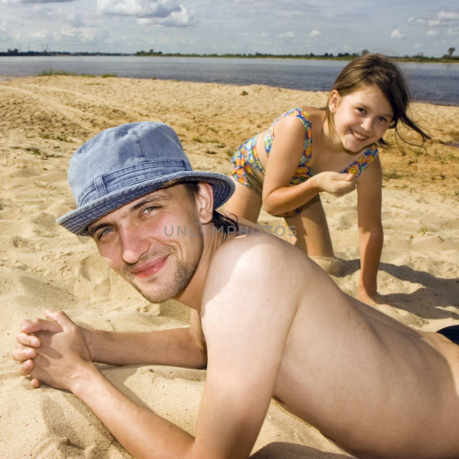 The young man and the girl on a beach at the river