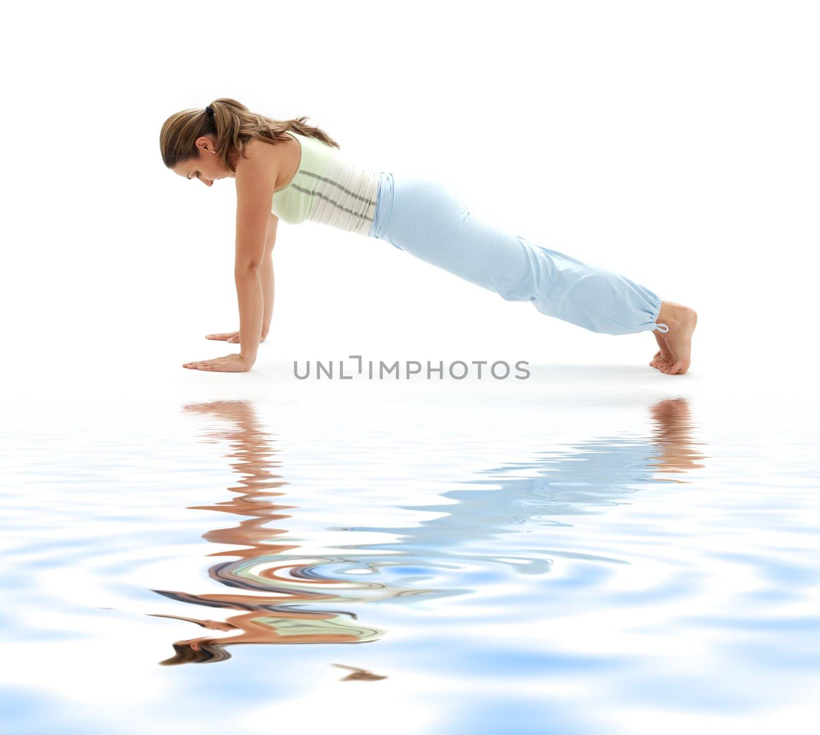 sporty girl practicing chaturanga dandasana four-limbed staff pose on white sand