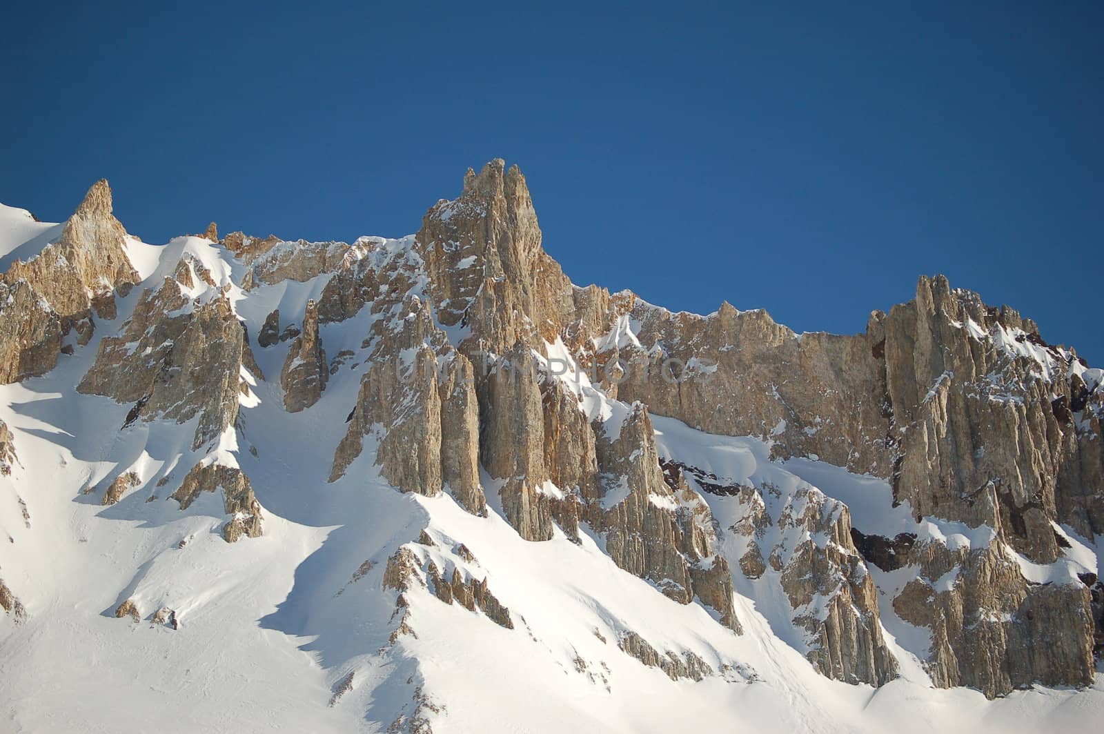 Snow-covered mountain tops with deep blue sky in Patagonia winter resorts