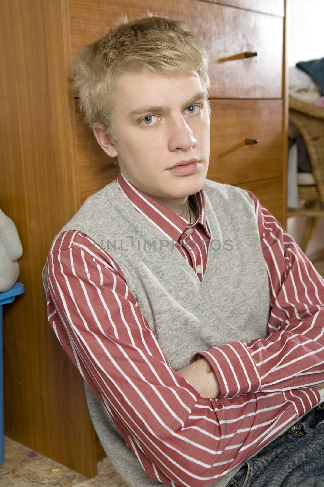 portrait of young handsome blond man sitting on the floor
