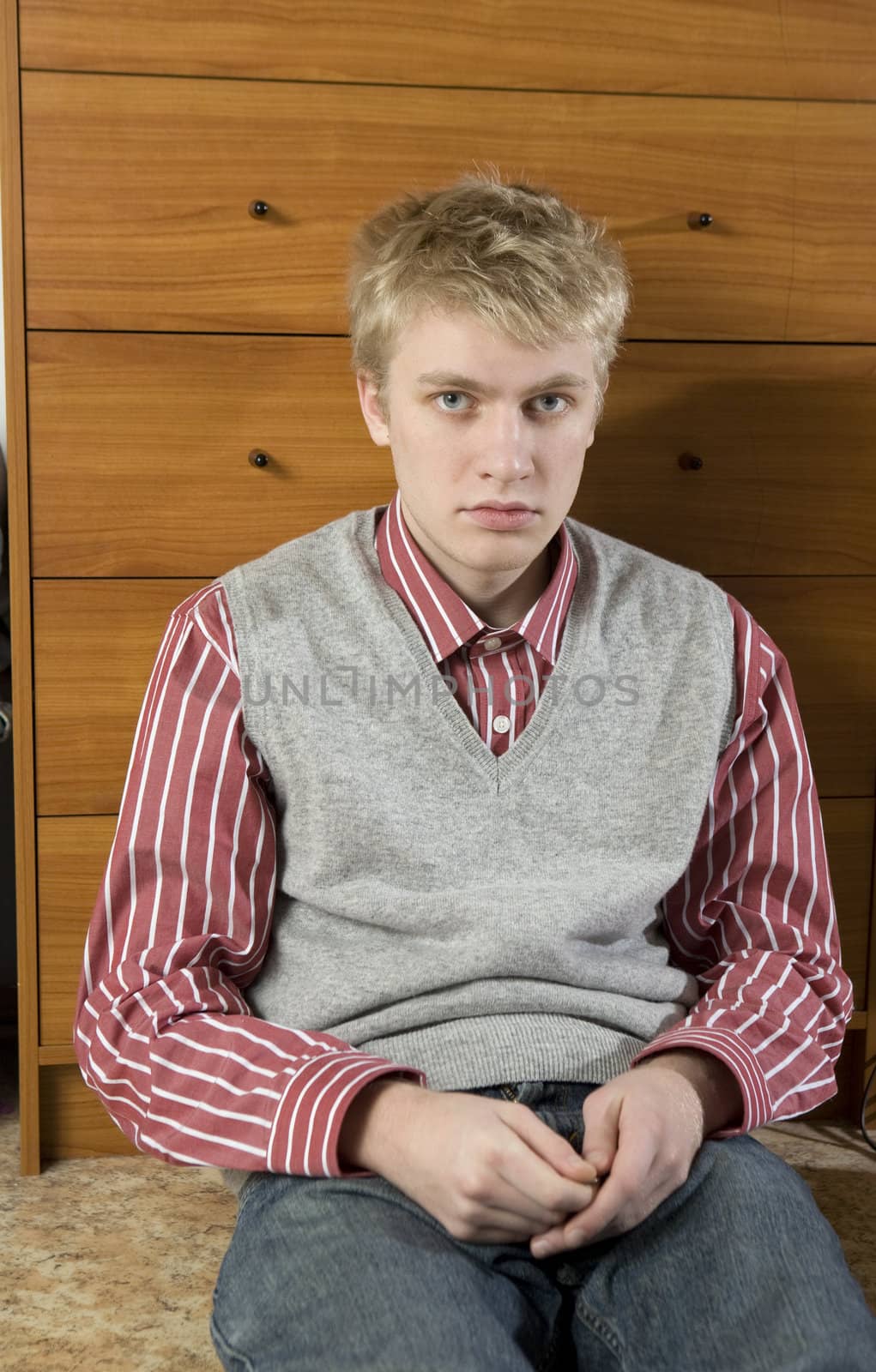 portrait of young handsome blond man sitting on the floor by elenarostunova