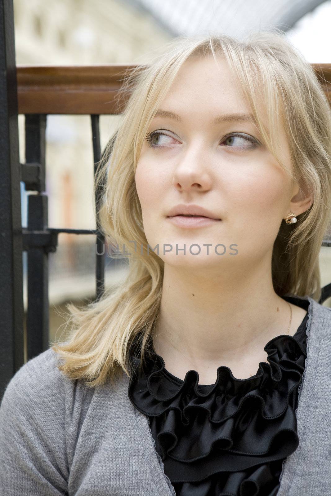portrait of young serious attractive tired blond woman with blue eyes