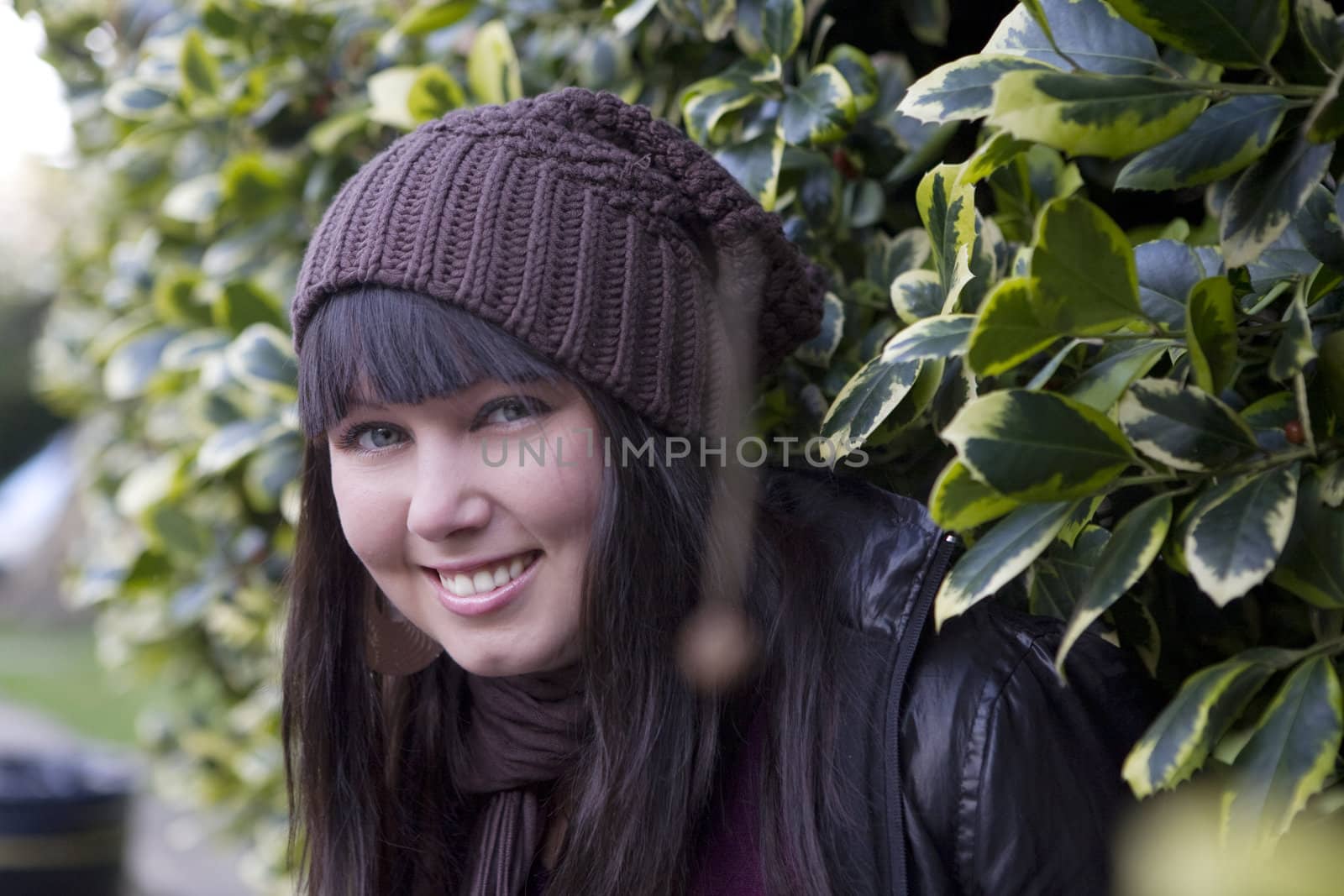 smiling girl looking from  green bush by elenarostunova