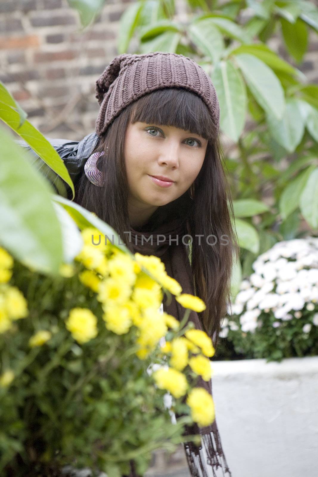portrait young attractive pensive woman wearing cap standing near flower chrysanthemum
