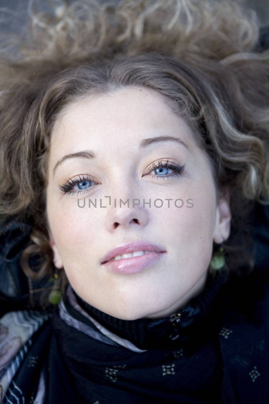 closeup portrait young curl blond woman with blue eyes