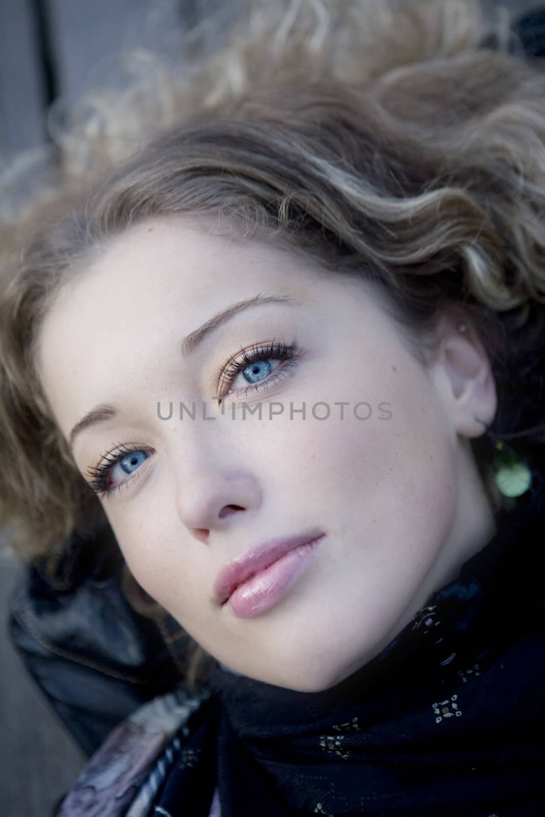 closeup portrait young curl blond woman with blue eyes