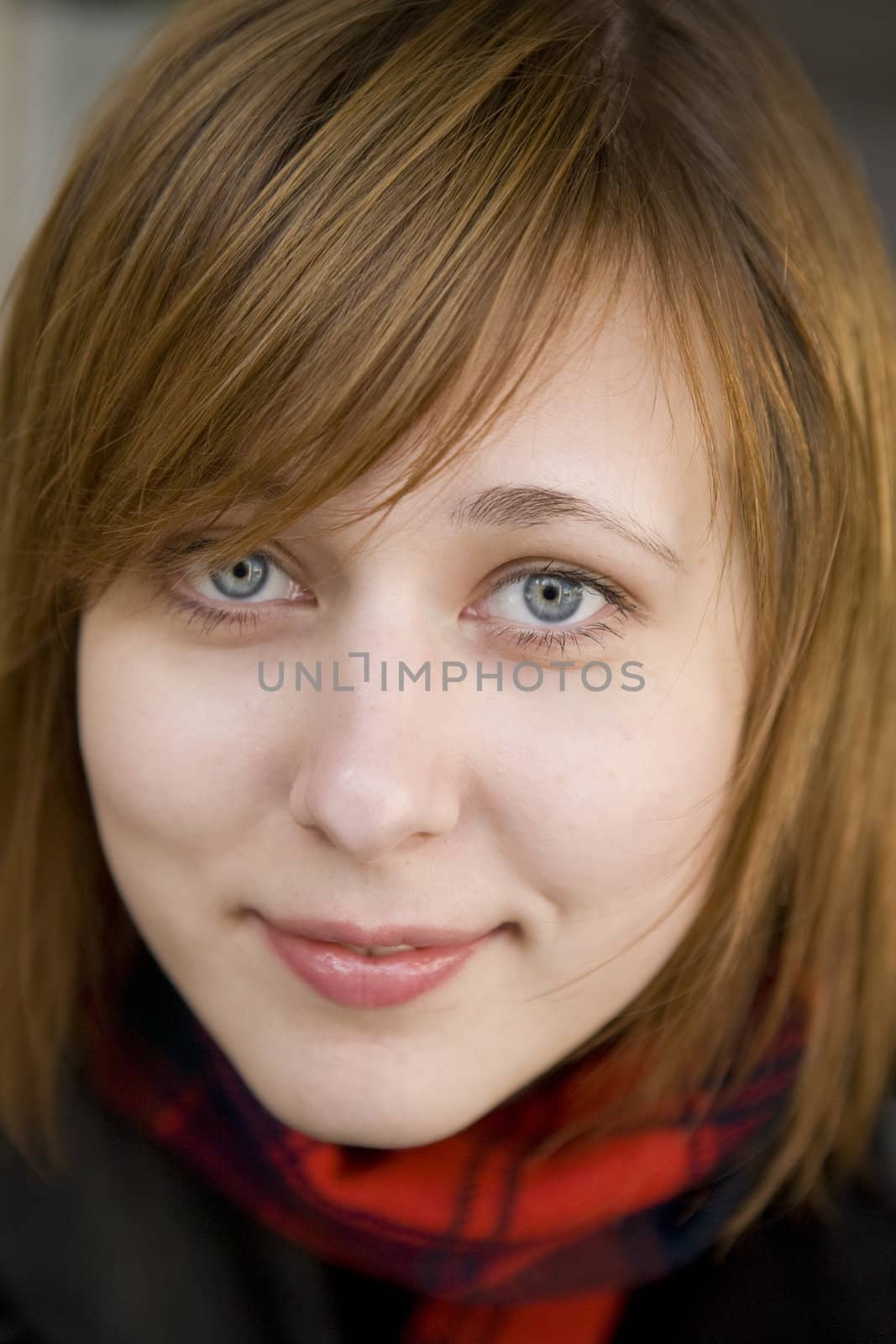 closeup portrait of young serious attractive red hair woman with blue eyes