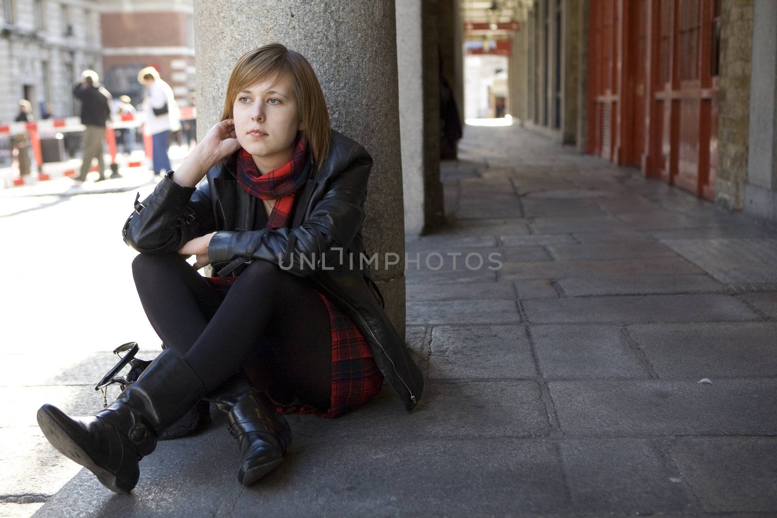 young attractive girl with red hair sitting on street, waiting. London. Covern Garden.