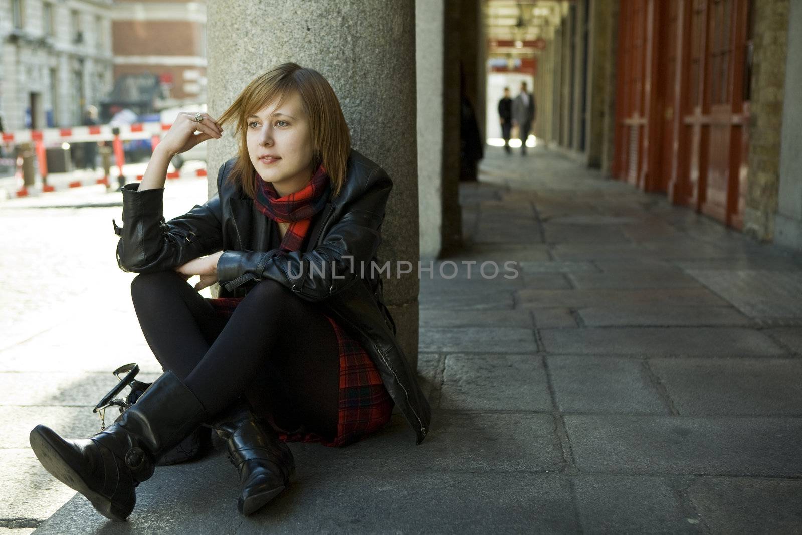 young attractive girl with red hair sitting on street, waiting.  by elenarostunova