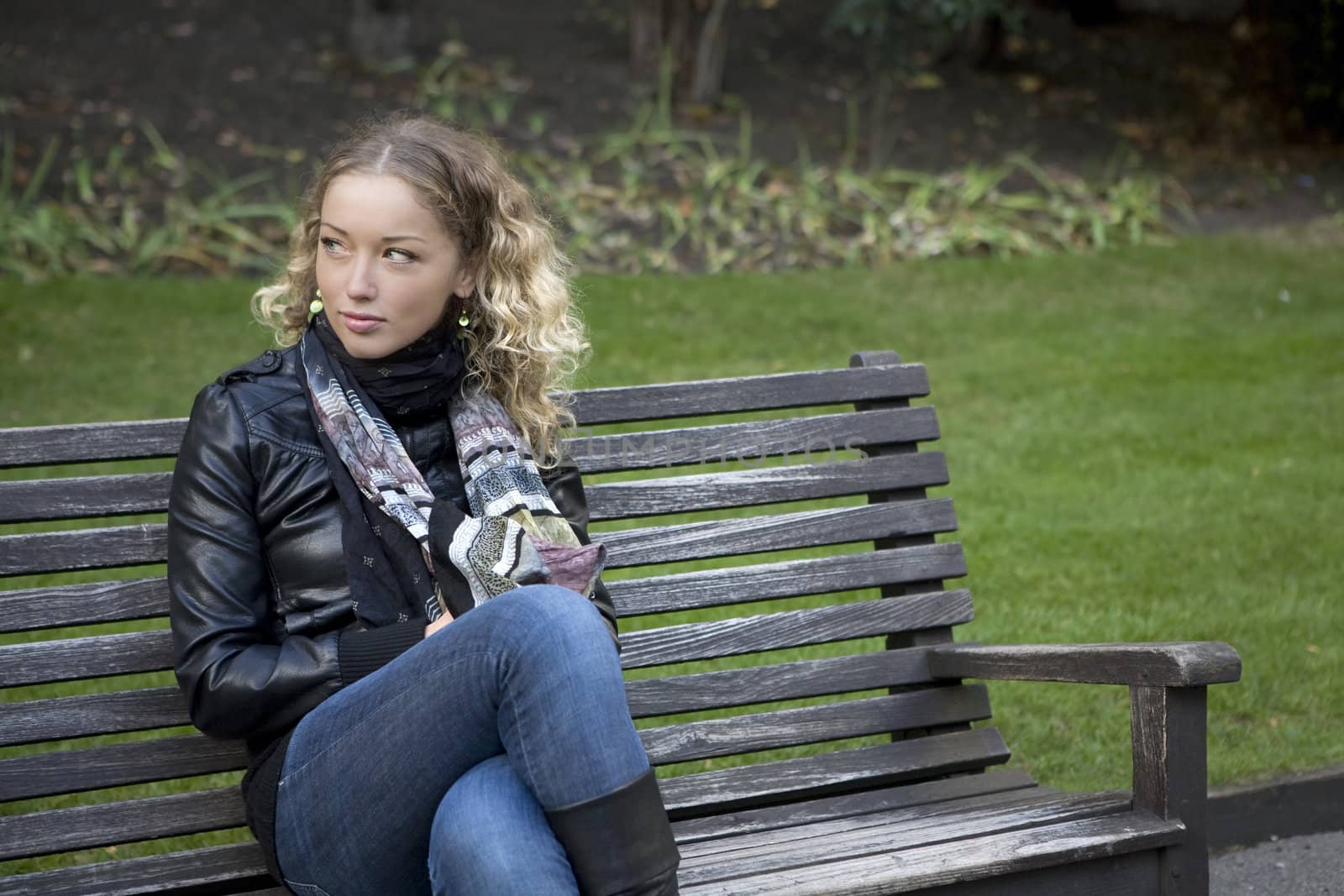 adorable girl sitting on the bench in the park