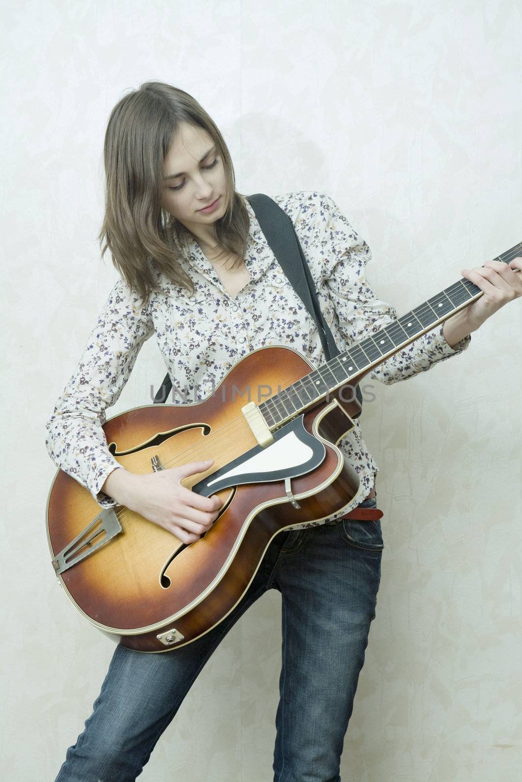 Attractive young girl playing guitar. Cowgirl