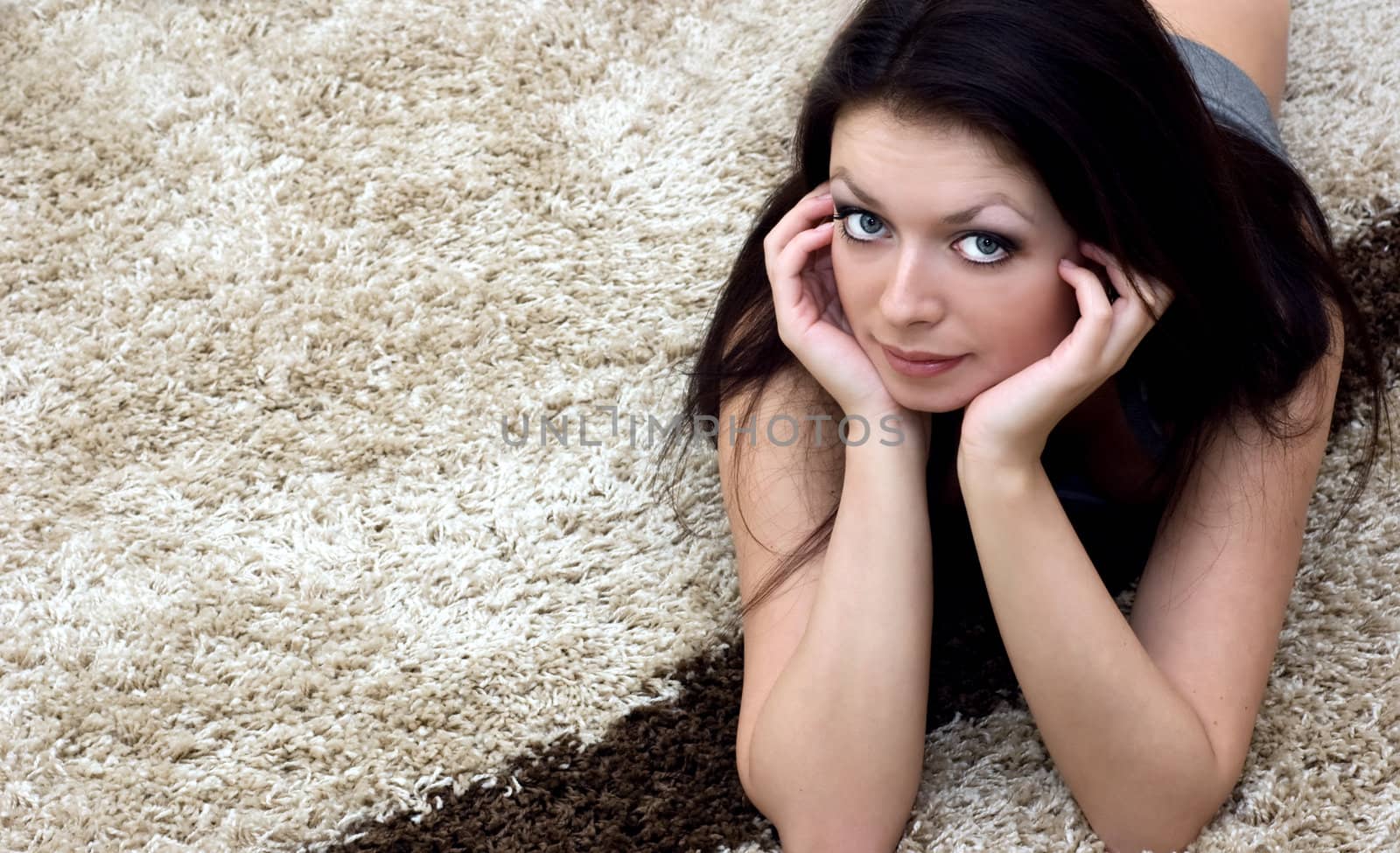 Beautiful brunette lying on carpet