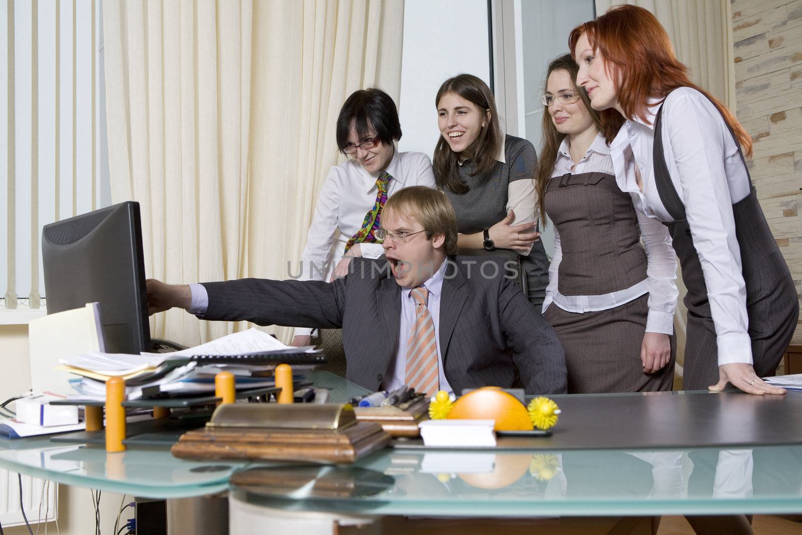 Five businesspeople  looking at laptop in office. Boss with colleagues. Boss shut loudly point to laptop.  Colleagues are  laughing. Interior of office.