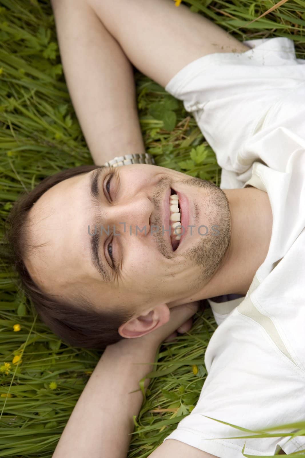 The smiling man has a rest on a grass
